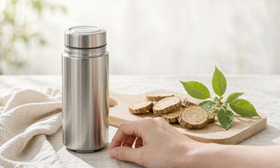A hand beside a travel cup and sliced burdock root on a sunlit outdoor table