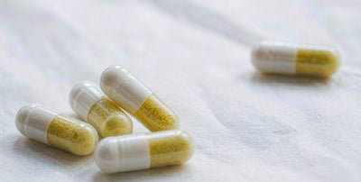 Macro view of plain unlabeled supplement capsules on a bright white surface in daylight