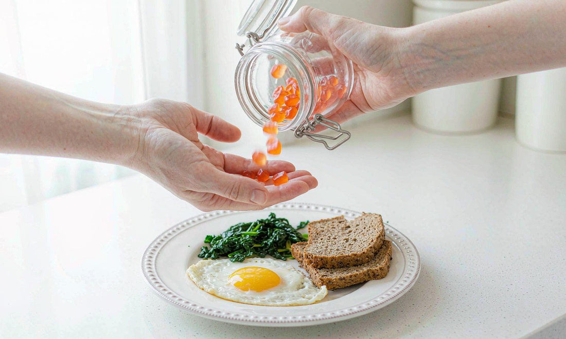 Fair-skinned hands holding a gummy jar over eggs, greens and whole grain toast on a counter