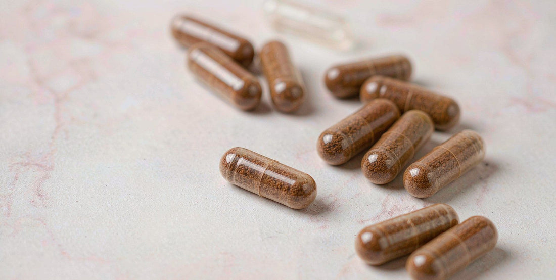 Macro view of plain beef liver supplement capsules on pale marble, soft focus