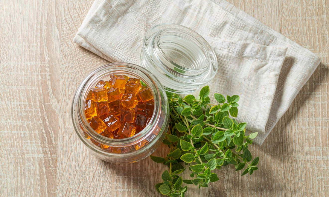 Bright flat-lay of an unlabeled gummy jar with fresh herbs on light oak, traditional beef liver nutrition