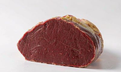 Extreme macro of a fresh grass-fed beef liver slice showing deep red texture and fine grain detail