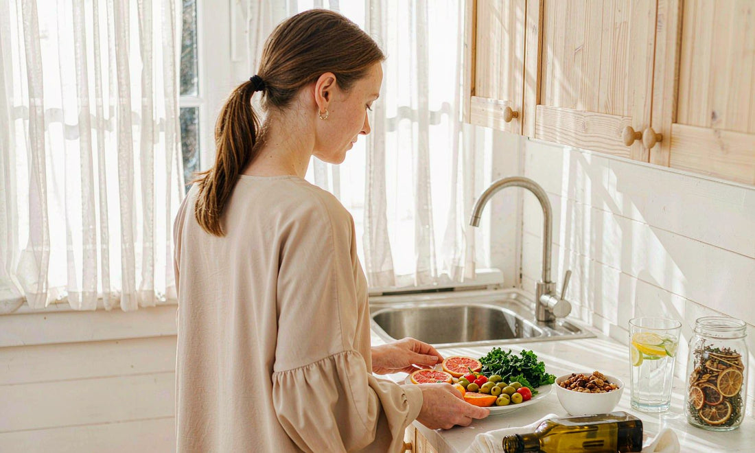 Bright kitchen with a woman preparing a healthy plate, seen from behind