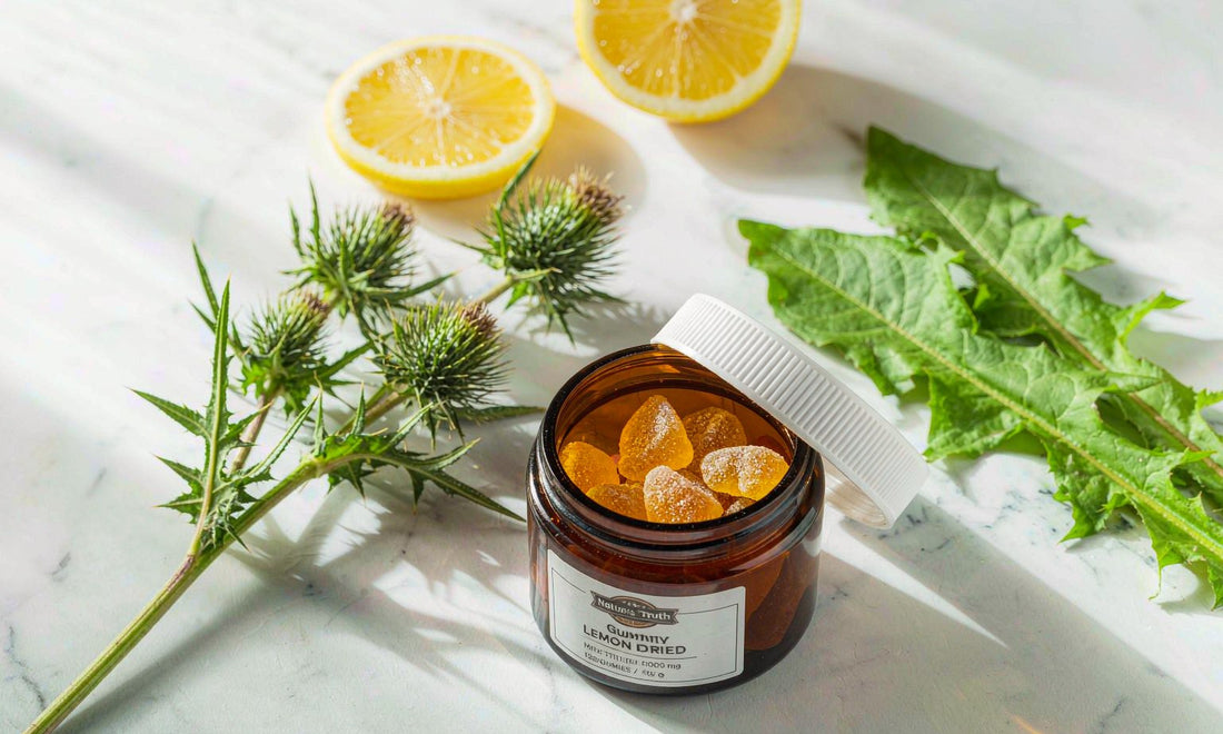 Flat lay of a TUDCA gummy jar with lemon slices and herbs