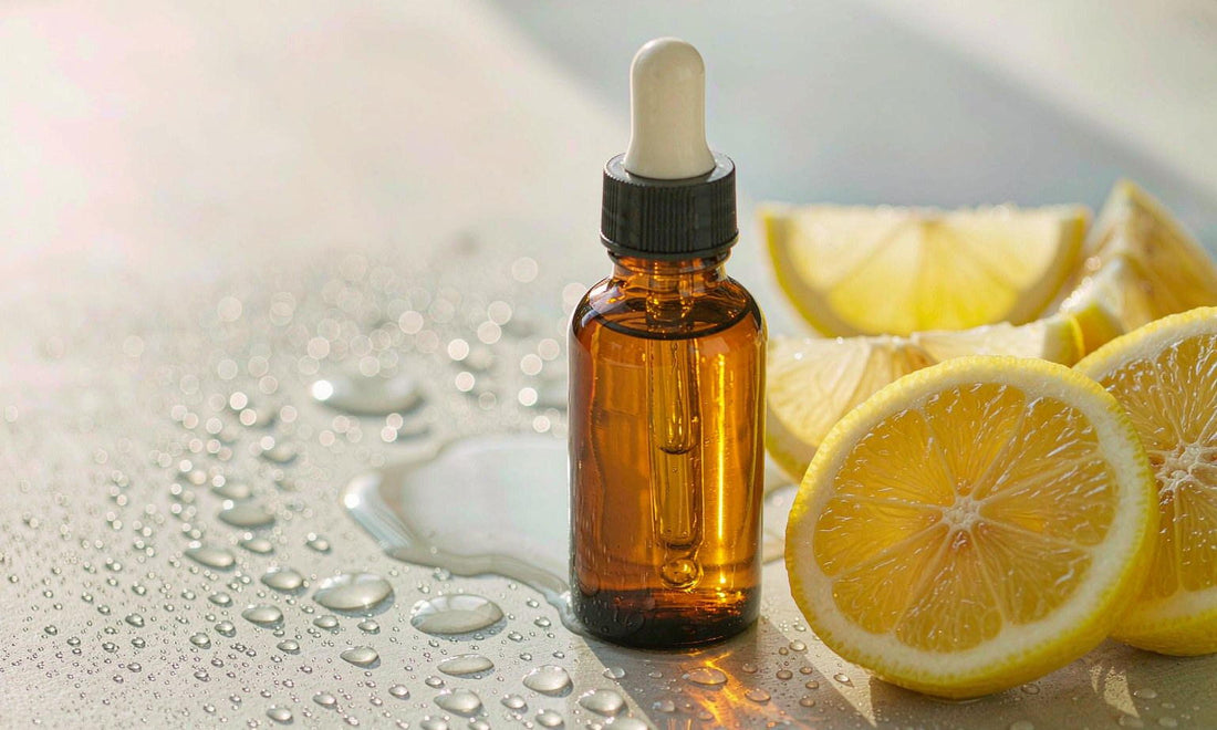 Plain unlabeled dropper bottle beside fresh lemon slices and water droplets on a light surface.