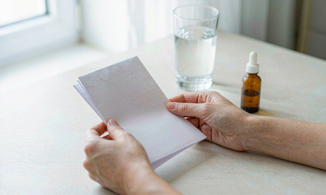 Fair-skinned hands holding a folded lab report beside an amber dropper bottle and a glass of water